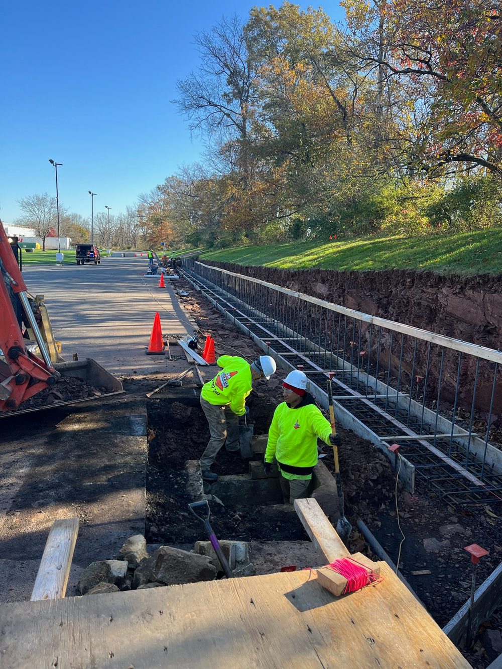 Beckage Sealcoating crew setting rebar and forms for a new concrete curb along a commercial parking lot edge in NJ